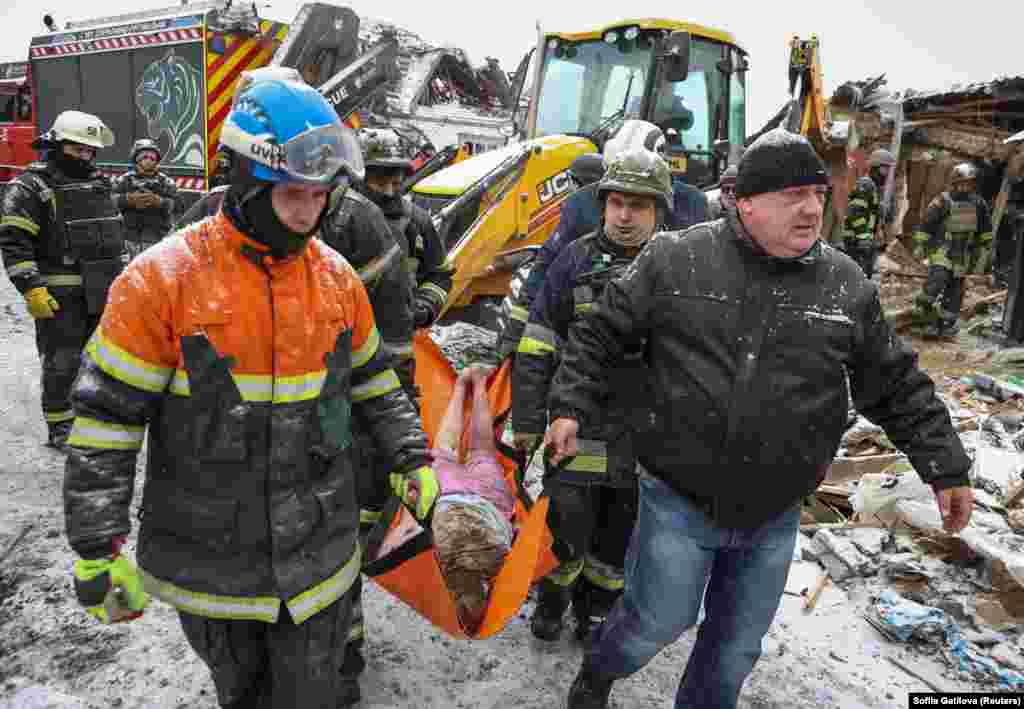 Rescuers remove the body of a woman who was killed during a Russian missile strike on the town of Zmiyiv, in the eastern region of Kharkiv, on January 8. Moscow launched a massive wave of missile strikes across Ukrainian regions, killing at least four civilians, wounding at least 40, and causing damage to infrastructure and economic facilities, Ukrainian officials and the military said.