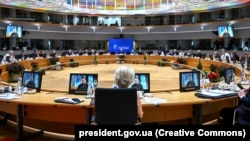 Ukrainian President Volodymyr Zelenskiy (onscreen) addresses the European Council in Brussels on December 14.