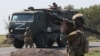 Russian soldiers guard a road as a Russian military convoy in Zaporizhzhya, Ukraine. 