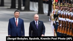 Президент Китаю Сі Цзіньпін (ліворуч) і очільник Росії Путін ідуть повз почесну варту у Пекіні. Китай, 2024 рік