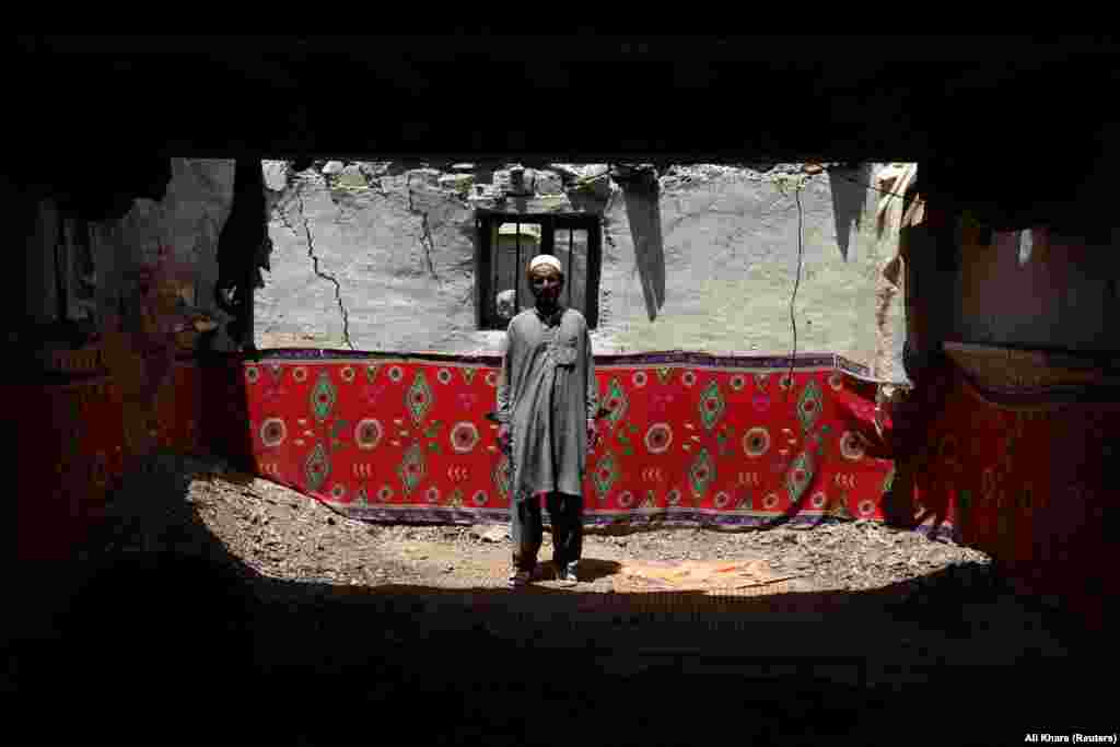 Ahmad Vali poses for a photograph inside his damaged house in Gayan.