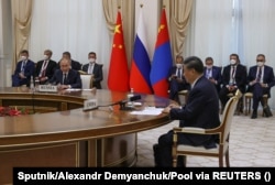 Си Цзиньпин (справа на первом плане) и Владимир Путин (слева на первом плане) на встрече на полях саммита Шанхайской организации сотрудничества в Узбекистане в сентябре.