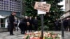 German Chancellor Angela Merkel (2nd L), German Interior Minister Thomas de Maiziere (3rd L) and Berlin's mayor Michael Mueller (L) stand at a makeshift memorial for the victims of an attack in front of the Kaiser Wilhelm Memorial Church in Berlin on December 20.