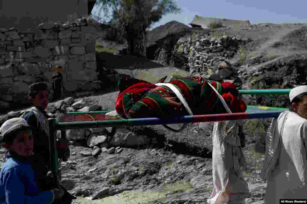 Afghan boys carry the body of a child who was killed in the Golam Kot district in Paktika Province. 