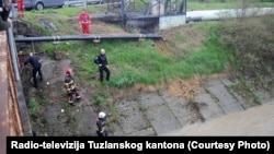 Vatrogasci pored korita rijeke u potrazi za dvije osobe, Tuzla, Bosna i Hercegovina. 