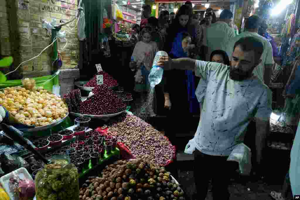 Prodavač prska vodom voće na bazaru Tadžriš u Teheranu, Iran, 28. augusta.