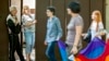 Residents look out from the doorway of their home as LGBT supporters pass during a march for human rights in downtown Chisinau in May.