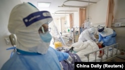 CHINA -- Medical workers in protective suits attend to a patient inside an isolated ward of Wuhan Red Cross Hospital in Wuhan, the epicentre of the novel coronavirus outbreak, in Hubei province, China February 16, 2020.