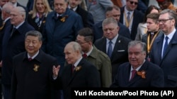 Vladimir Putin razgovara sa Si Đinpingom na ceremoniji polaganja vijenaca povodom Dana pobjede, sa Miloradom Dodikom i Aleksandrom Vučićem u pozadini, Moskva, 9. maj 2025.