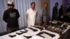 Pakistani security official displays weapons recovered during a security operation in Karachi on November 7, 2016.