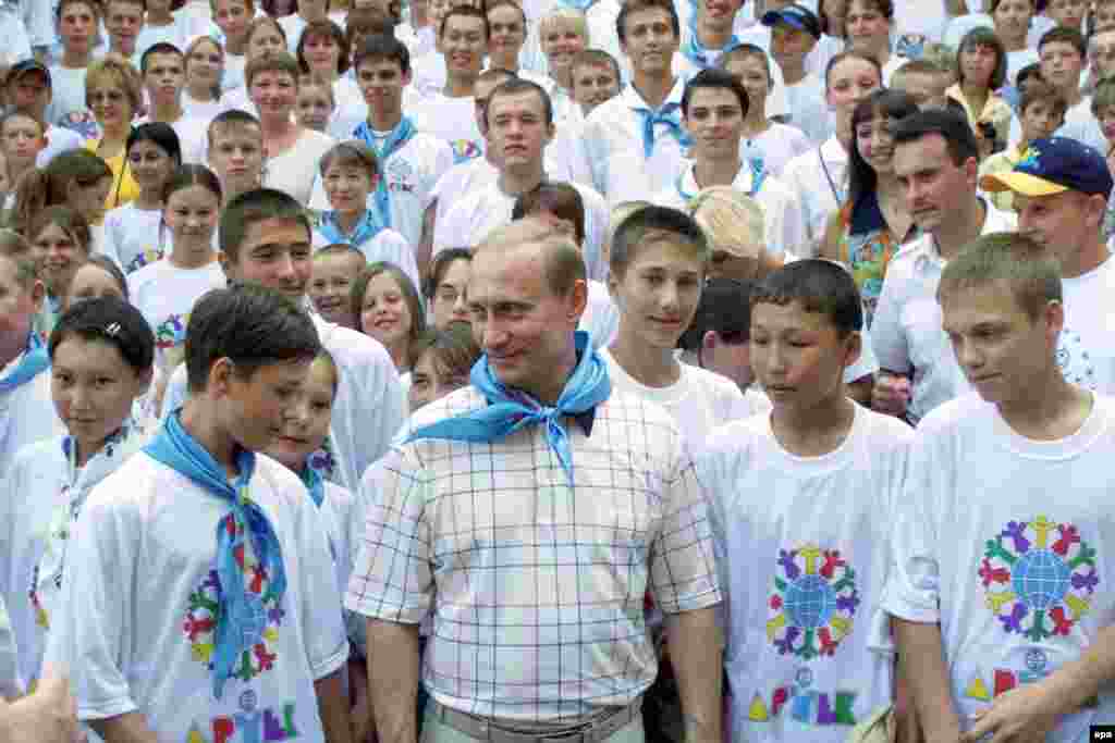 Путин в "Артеке", 2001 год: после распада СССР "Артек" из пионерского лагеря превратился в "Международный детский центр", а галстуки вместо алого цвета стали голубыми.