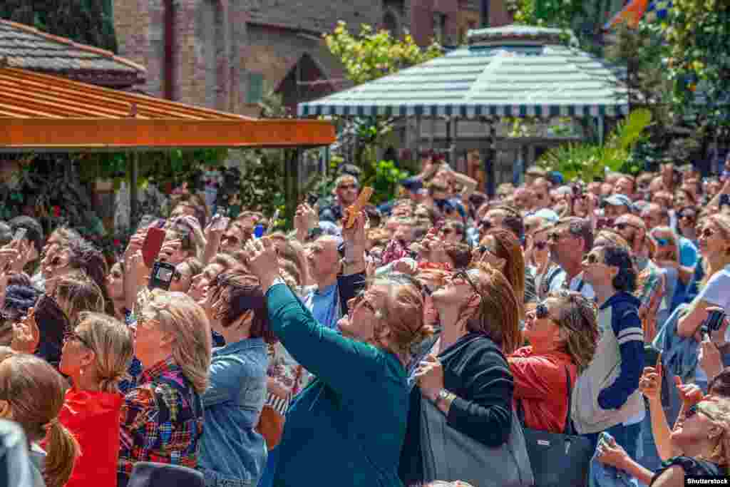 Crowds gather under the tower in the summer of 2019. Every hour, doors open on the tower to reveal mannequins enacting a kind of “circle of life.”