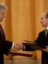 Russian President Vladimir Putin (right) and US President Bill Clinton exchange agreements on the establishment of a joint warning center for the exchange of information on missile launches shortly after signing them, in Moscow on June 4, 2000.