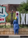 Уборщица на фоне городских украшений в честь 70-летия Ахмата Кадырова, архивное фото