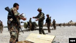 FILE: Members of the Afghan security forces take their positions during an operation against the Taliban in southern Afghanistan.