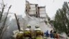 Ukrainian rescue workers clear debris as they work at the site of a destroyed residential building following a Russian air attack on Kyiv. 