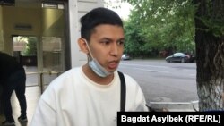 Temirlan Ensebek talks to reporters outside a police station in Almaty on May 15.