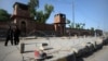 Pedestrians walk past the jail where Pakistani physician Shakil Afridi is being held after he was sentenced to 33 years in prison for helping U.S. forces kill Osama bin Laden.
