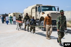 Afghan medical and Taliban security personnel carry stretchers for evacuated earthquake victims near Jalalabad.